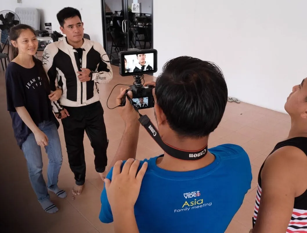 Project Video Asia camera operator filming two people on a monitor rig in studio