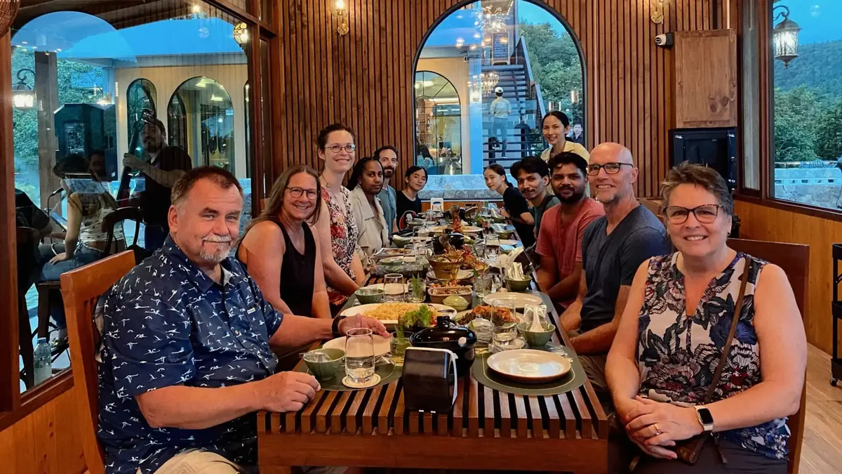 Create International team members sharing a meal around a long table